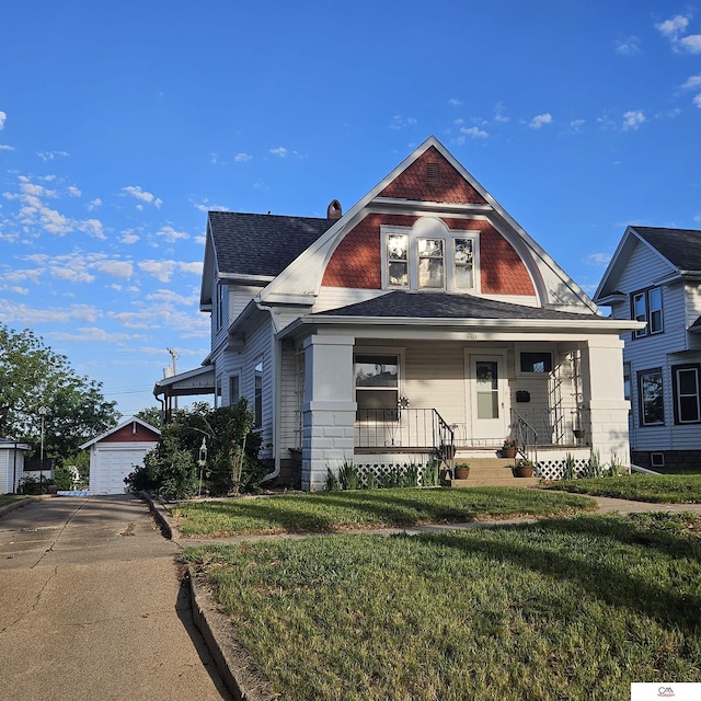 1119 H St, Fairbury, NE 68352 - view of front of house with a porch, an outbuilding, a front lawn, a detached garage, and roof with shingles