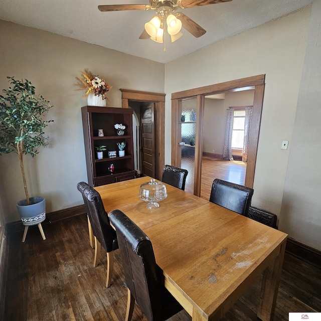 1119 H St, Fairbury, NE 68352 - dining area featuring dark wood-type flooring, a ceiling fan, and baseboards