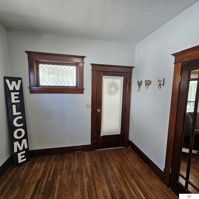 1119 H St, Fairbury, NE 68352 - entrance foyer with dark wood-style flooring, baseboards, and a textured ceiling