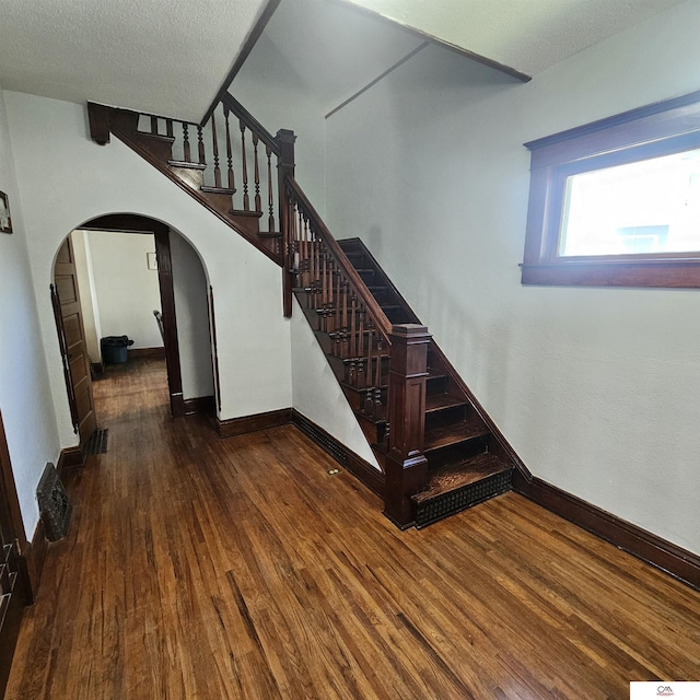 1119 H St, Fairbury, NE 68352 - stairway featuring arched walkways, wood finished floors, and baseboards