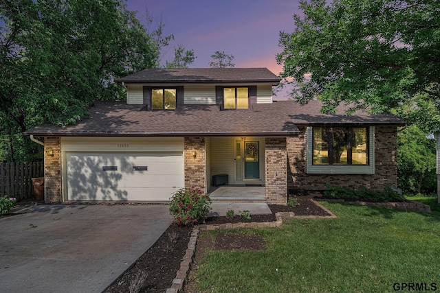13055 Brookside Dr, Bellevue, NE 68123 - tri-level home featuring driveway, brick siding, and an attached garage