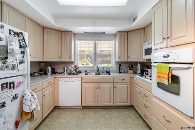 2206 N 56th St, Omaha, NE 68104 - kitchen featuring white appliances, a sink, light brown cabinetry, a tray ceiling, and light countertops