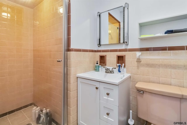 2206 N 56th St, Omaha, NE 68104 - bathroom featuring a shower stall, vanity, tile walls, a wainscoted wall, and toilet