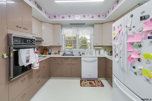 2206 N 56th St, Omaha, NE 68104 - kitchen featuring white appliances, under cabinet range hood, a sink, and light countertops
