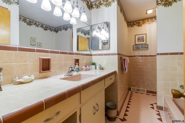 2206 N 56th St, Omaha, NE 68104 - bathroom featuring vanity, a bath, tile walls, a wainscoted wall, and tile patterned flooring