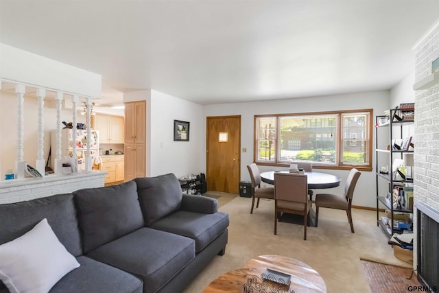 2206 N 56th St, Omaha, NE 68104 - living room featuring light colored carpet, a brick fireplace, and baseboards