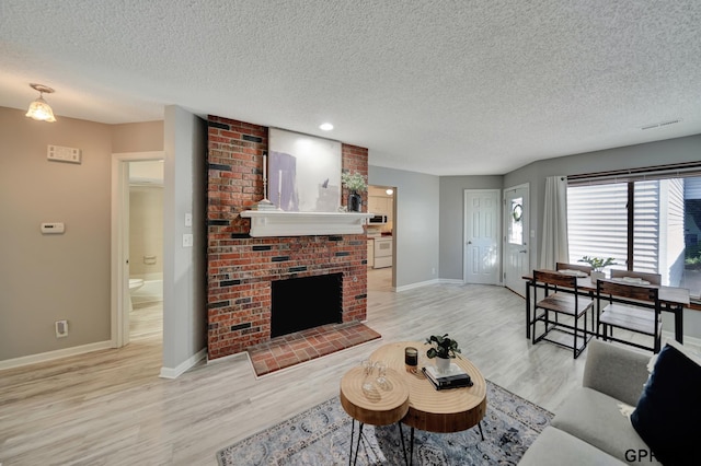 1625 Granada Ln, Lincoln, NE 68528 - living area featuring a textured ceiling, light wood-style flooring, baseboards, a brick fireplace, and recessed lighting