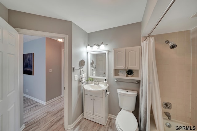 1625 Granada Ln, Lincoln, NE 68528 - full bath featuring wood finished floors, vanity, toilet, shower / bathtub combination with curtain, and baseboards
