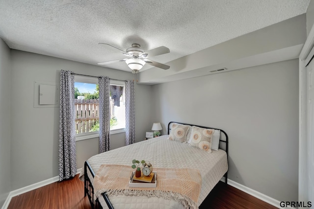 1625 Granada Ln, Lincoln, NE 68528 - bedroom featuring baseboards, dark wood finished floors, a ceiling fan, and a textured ceiling