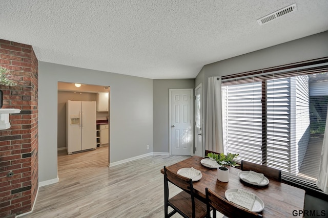1625 Granada Ln, Lincoln, NE 68528 - dining area with a textured ceiling, light wood-style floors, and baseboards