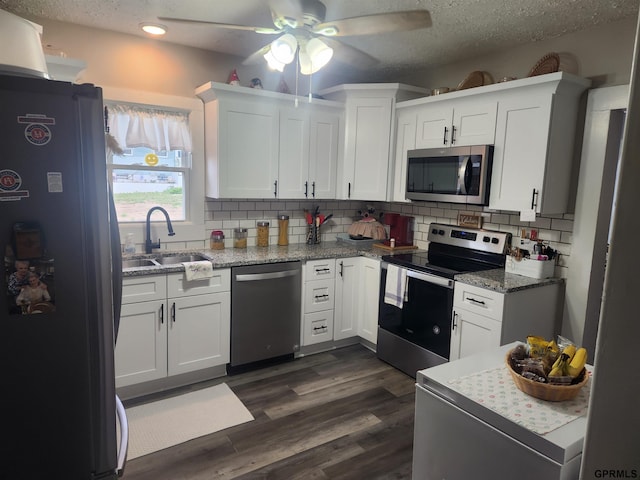 1211 D St, Fairbury, NE 68352 - kitchen featuring appliances with stainless steel finishes, ceiling fan, tasteful backsplash, a sink, and a textured ceiling