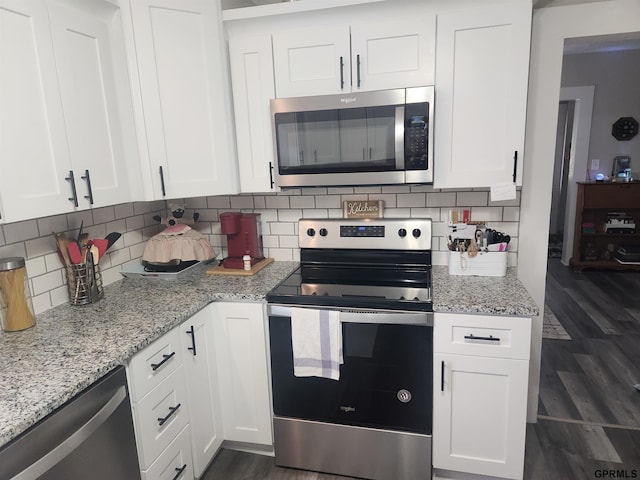 1211 D St, Fairbury, NE 68352 - kitchen featuring stainless steel appliances, white cabinetry, dark wood-type flooring, and backsplash