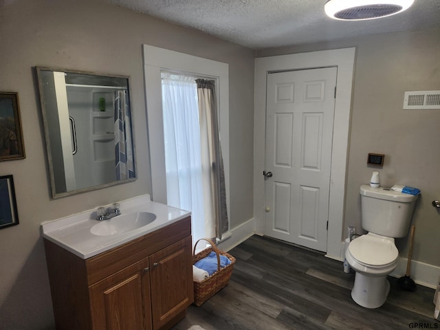 1211 D St, Fairbury, NE 68352 - full bathroom featuring vanity, toilet, wood finished floors, a textured ceiling, and a shower