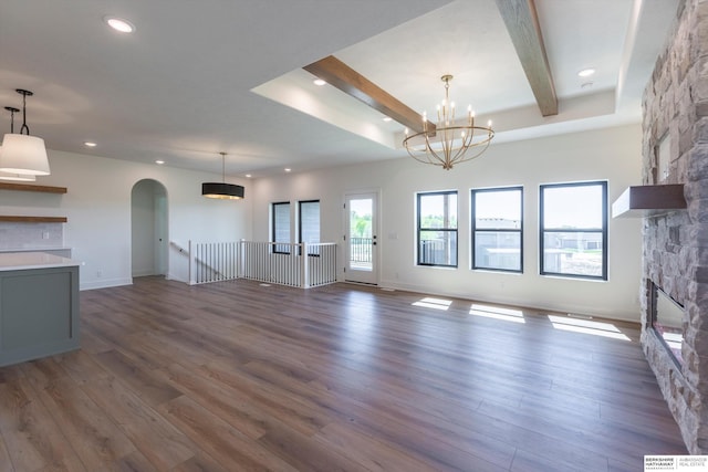 11019 N 166th St, Bennington, NE 68007 - unfurnished living room featuring a stone fireplace, arched walkways, recessed lighting, wood finished floors, and baseboards