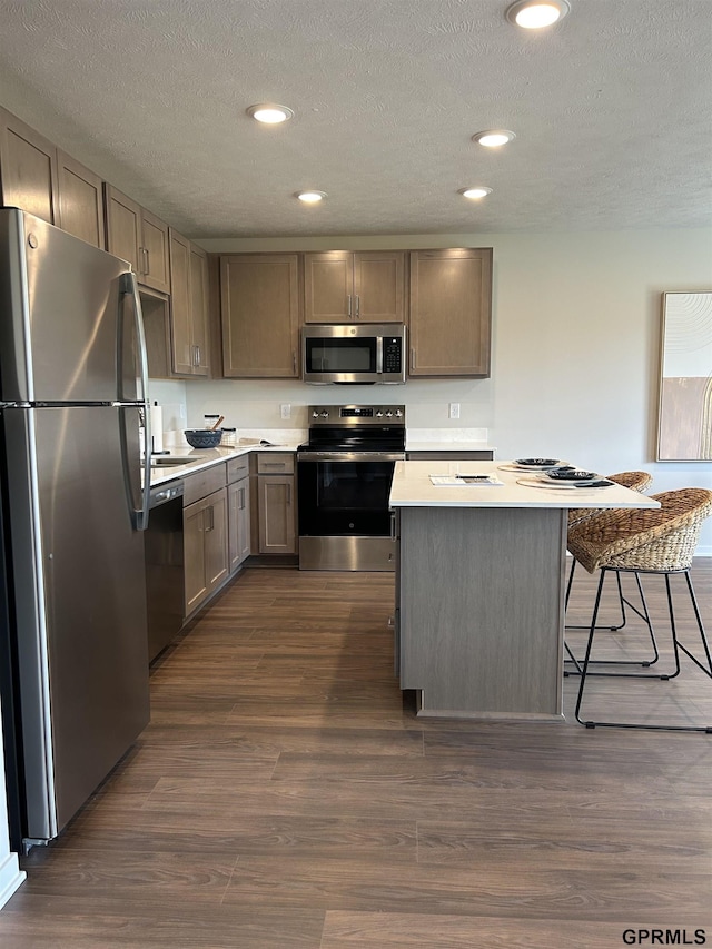 545 W Corsac Rd, Lincoln, NE 68523 - kitchen featuring stainless steel appliances, light countertops, dark wood-type flooring, a kitchen breakfast bar, and a center island
