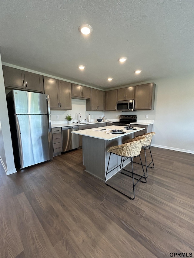 545 W Corsac Rd, Lincoln, NE 68523 - kitchen with stainless steel appliances, baseboards, light countertops, a center island, and dark wood-type flooring