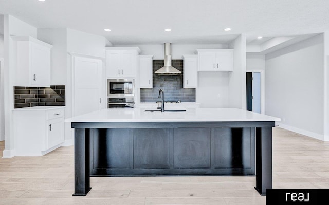 12003 S 109th St, Papillion, NE 68046 - kitchen featuring wall chimney exhaust hood, appliances with stainless steel finishes, a spacious island, a sink, and white cabinetry
