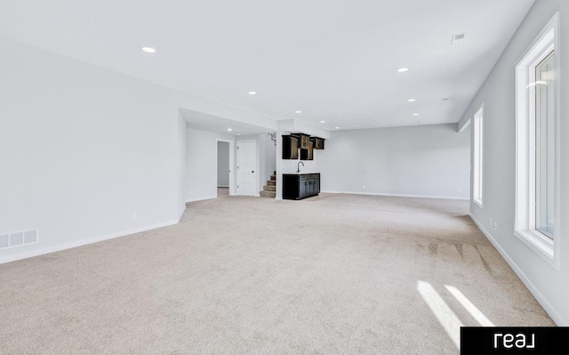 12003 S 109th St, Papillion, NE 68046 - unfurnished living room with light colored carpet, recessed lighting, baseboards, plenty of natural light, and stairway