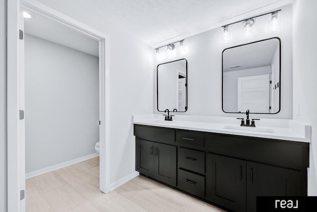 12003 S 109th St, Papillion, NE 68046 - bathroom featuring double vanity, toilet, baseboards, and a textured ceiling