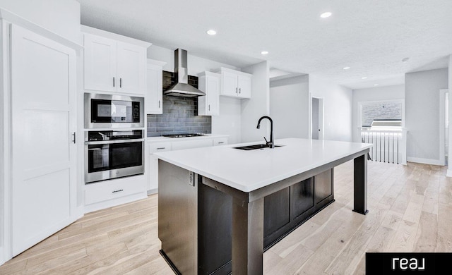 12003 S 109th St, Papillion, NE 68046 - kitchen featuring stainless steel appliances, a sink, wall chimney exhaust hood, a center island with sink, and backsplash