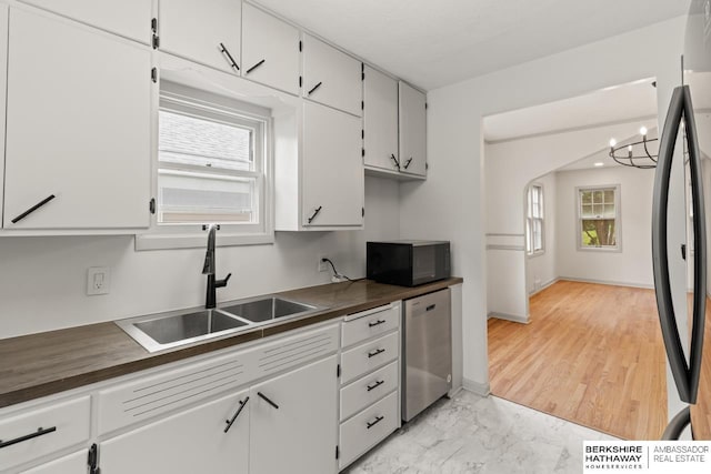 2035 N 50th St, Omaha, NE 68104 - kitchen with stainless steel dishwasher, black microwave, a sink, freestanding refrigerator, and dark countertops