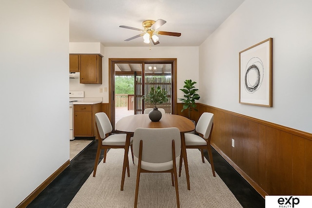 813 Janes View St, Papillion, NE 68046 - dining room featuring ceiling fan, a wainscoted wall, wood walls, and light wood-style flooring