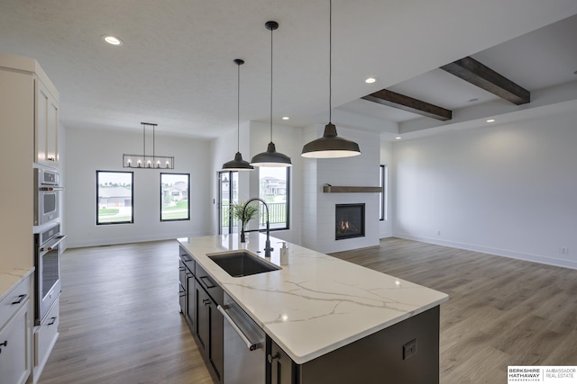5717 S 200th Cir, Omaha, NE 68135 - kitchen with a sink, open floor plan, dishwasher, a large fireplace, and recessed lighting