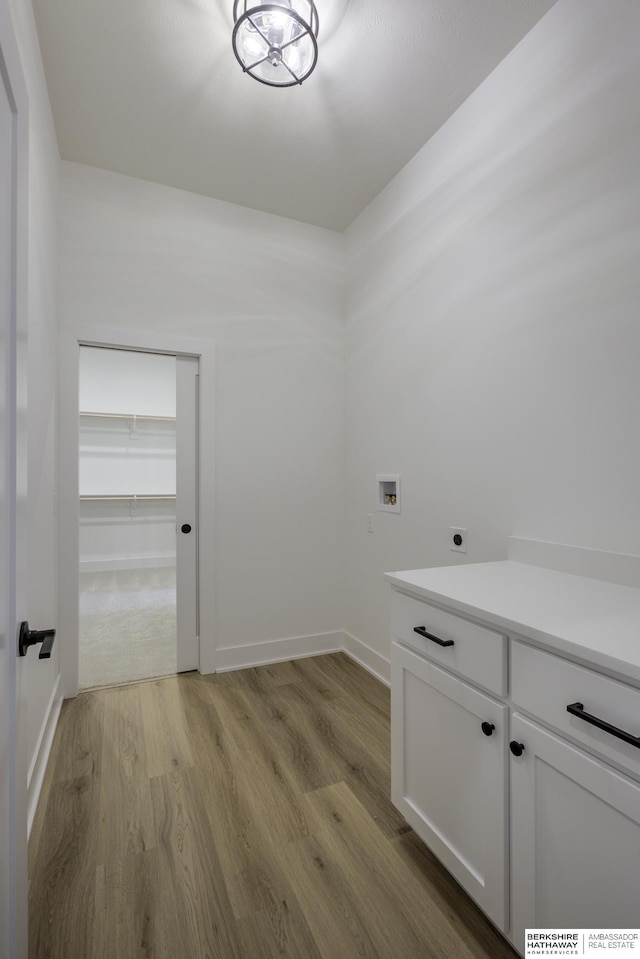 5717 S 200th Cir, Omaha, NE 68135 - laundry room featuring hookup for a washing machine, hookup for an electric dryer, light wood-style floors, baseboards, and cabinet space
