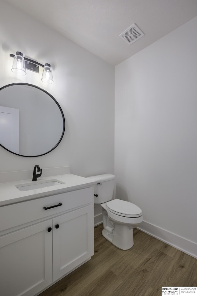 5717 S 200th Cir, Omaha, NE 68135 - half bathroom featuring wood finished floors, vanity, toilet, and baseboards