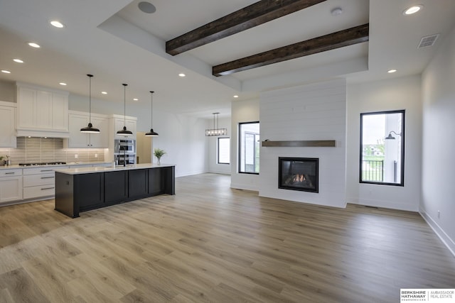 5717 S 200th Cir, Omaha, NE 68135 - kitchen with open floor plan, stainless steel gas stovetop, light countertops, white cabinetry, and light wood-style floors