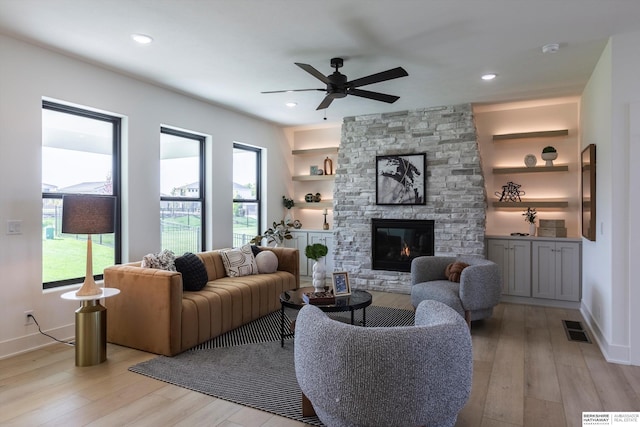 6617 S 214th St, Omaha, NE 68022 - living room featuring a stone fireplace, light wood-style flooring, a ceiling fan, baseboards, and recessed lighting