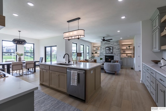 6617 S 214th St, Omaha, NE 68022 - kitchen with stainless steel dishwasher, a sink, a stone fireplace, ceiling fan, and light countertops