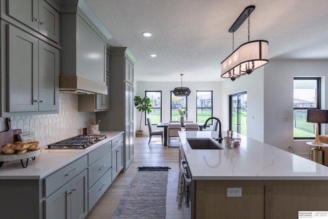 6617 S 214th St, Omaha, NE 68022 - kitchen with a sink, stainless steel gas cooktop, gray cabinets, decorative backsplash, and an island with sink