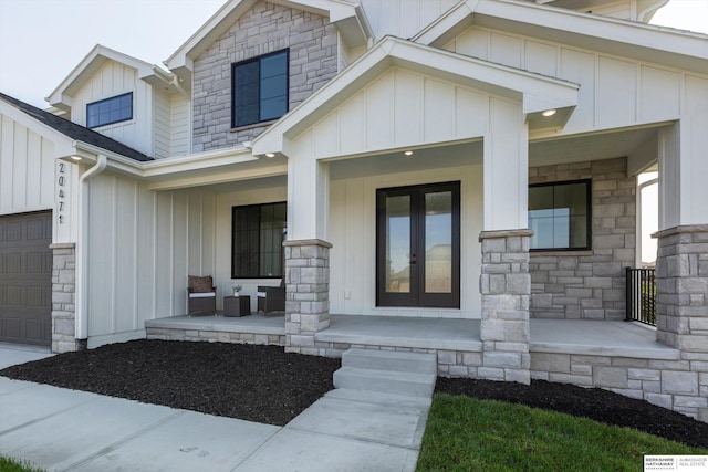 6617 S 214th St, Omaha, NE 68022 - view of exterior entry with covered porch, board and batten siding, stone siding, french doors, and a garage
