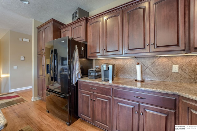 18855 Mason Plz, Omaha, NE 68022 - kitchen featuring freestanding refrigerator, light wood-type flooring, backsplash, baseboards, and light stone counters