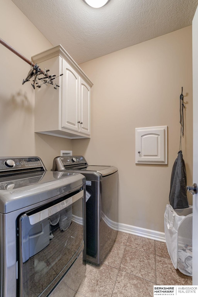 18855 Mason Plz, Omaha, NE 68022 - laundry room featuring cabinet space, washer and dryer, baseboards, a textured ceiling, and light tile patterned floors