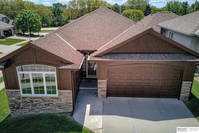 18855 Mason Plz, Omaha, NE 68022 - view of front facade with stone siding, roof with shingles, a garage, and driveway