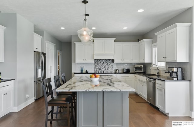 20956 Pine Cir, Elkhorn, NE 68022 - kitchen with stainless steel appliances, a sink, a center island, dark wood finished floors, and recessed lighting