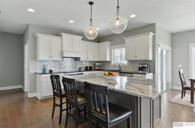 20956 Pine Cir, Elkhorn, NE 68022 - kitchen featuring a sink, baseboards, decorative backsplash, a kitchen island, and recessed lighting