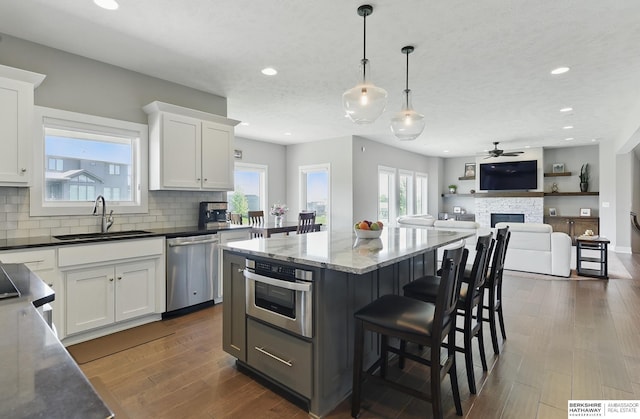 20956 Pine Cir, Elkhorn, NE 68022 - kitchen with stainless steel appliances, a sink, a fireplace, recessed lighting, and ceiling fan