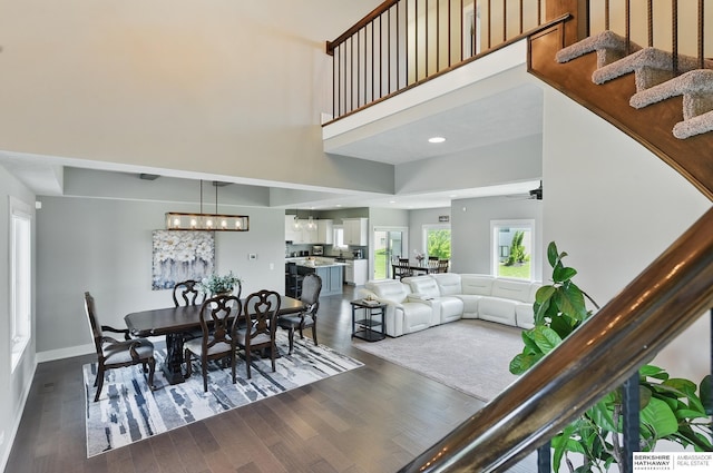 20956 Pine Cir, Elkhorn, NE 68022 - dining room with a towering ceiling, dark wood-style floors, stairs, a ceiling fan, and baseboards
