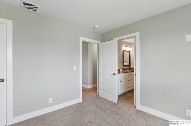 20956 Pine Cir, Elkhorn, NE 68022 - unfurnished bedroom with light colored carpet, baseboards, ensuite bath, and a sink