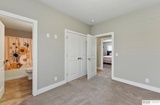 20956 Pine Cir, Elkhorn, NE 68022 - unfurnished bedroom featuring baseboards, carpet floors, ensuite bathroom, and a closet