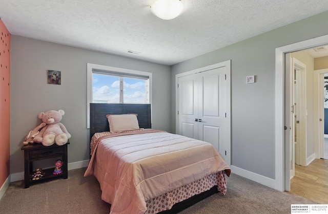20956 Pine Cir, Elkhorn, NE 68022 - bedroom featuring baseboards, a closet, light colored carpet, and a textured ceiling