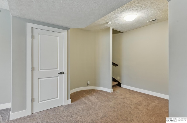 20956 Pine Cir, Elkhorn, NE 68022 - basement with a textured ceiling, carpet, baseboards, and stairway