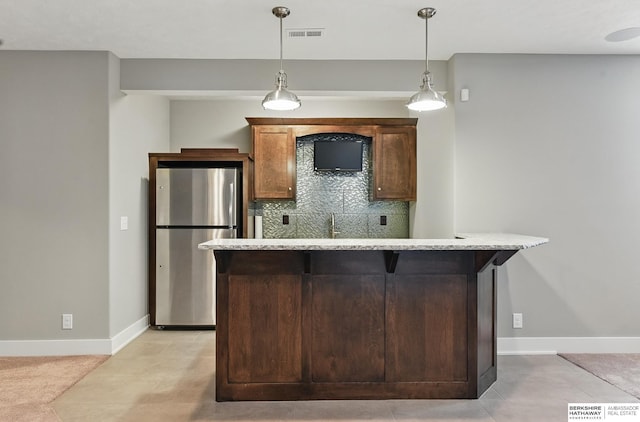 20956 Pine Cir, Elkhorn, NE 68022 - kitchen featuring freestanding refrigerator, pendant lighting, a center island, decorative backsplash, and baseboards