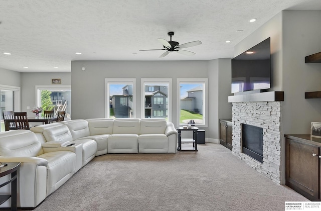 20956 Pine Cir, Elkhorn, NE 68022 - living area with ceiling fan, light carpet, a stone fireplace, recessed lighting, and a textured ceiling