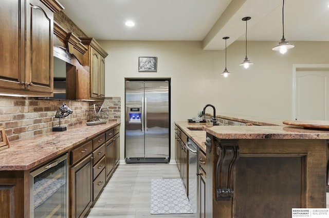 2025 S 189th Cir, Omaha, NE 68130 - kitchen with stainless steel appliances, wine cooler, a sink, backsplash, and hanging light fixtures