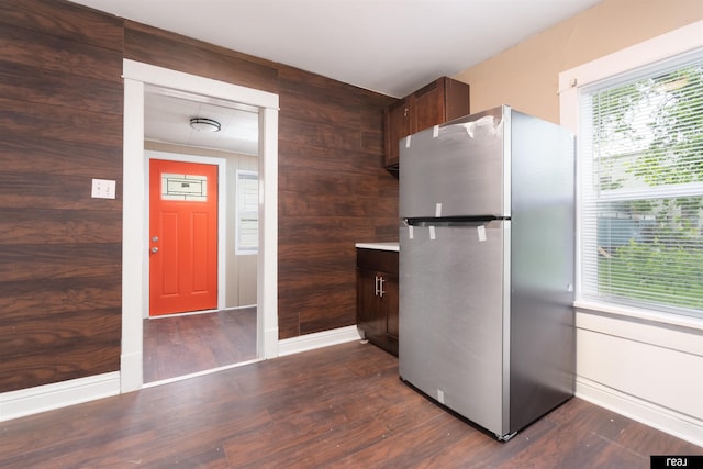 6935 Binney St, Omaha, NE 68104 - kitchen with freestanding refrigerator, wood walls, dark wood-style floors, dark brown cabinets, and light countertops