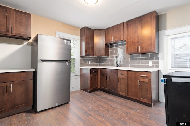 6935 Binney St, Omaha, NE 68104 - kitchen featuring freestanding refrigerator, light countertops, dark wood finished floors, and tasteful backsplash